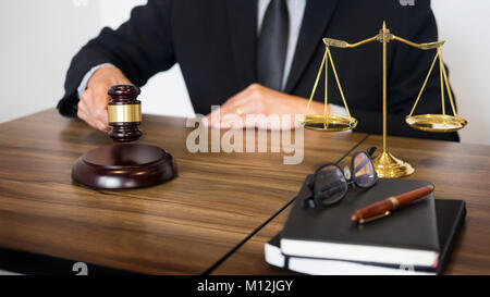 Männlichen Richter Rechtsanwalt In A Gerichtssaal auffällig The Hammer auf klingenden Block. Stockfoto