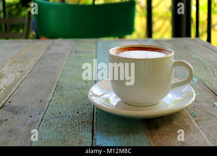 Geschlossen, eine Tasse heißen Cappuccino serviert auf rustikalen Holztisch, verschwommenen Hintergrund Stockfoto