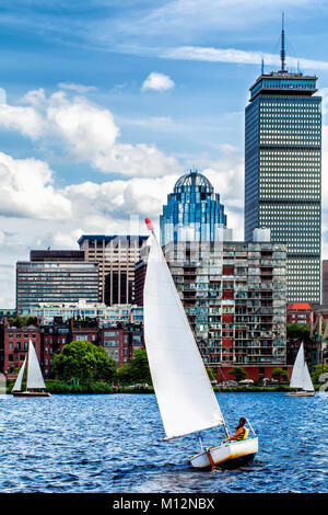 Segeln auf dem Charles River zwischen Cambridge und Boston an einem windigen Tag, mit Beacon Hill im Hintergrund zu sehen. Segelboot im Vordergrund. Stockfoto