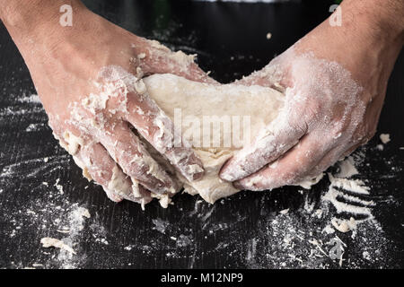 Männliche Hände Teig kneten, backen Vorbereitung Nahaufnahme. Stockfoto