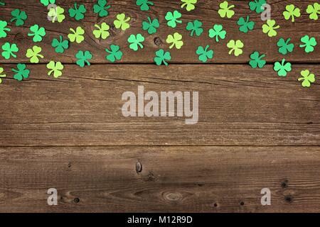 St Patricks Day oberer Rand des Papiers shamrocks über ein altes rustikales Holz Hintergrund Stockfoto
