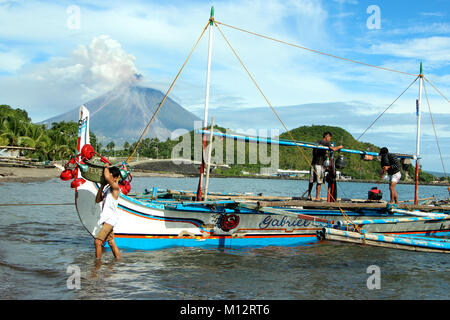 Brgy Buyoan, Legaspi, Albay City, Philippinen. Januar 25, 2018. Fisher's Leute Vorbereitung ihrer Angelausrüstung während Mt. Mayon speien, vulkanische Asche während des zweiten Ausbruch in der Morgen in Legaspi, Albay Stadt. Am 25. Januar 2018. Das philippinische Institut für Vulkanologie und Seismologie (PHILVOLCS) erklärt alert Nummer 8 und breiter der Gefahrenzone 8 Kilometer Fläche nach Explosionen die weiterhin aktiv Aktivitäten des Vulkans der vergangenen Tage. Credit: PACIFIC PRESS/Alamy leben Nachrichten Stockfoto