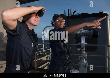 Pazifik (JAN. 13, 2018) der Bootsmann Mate 1. Klasse Kelly Pfaus (links), ein Eingeborener von San Antonio, und Seaman Danisha Haken, ein Eingeborener von Chicago, sowohl für die amphibische Landung dock Schiff USS Pearl Harbor (LSD 52), Blick von der aft Suche Position beim stehen sehen. Pearl Harbor, Teil der Amerika Amphibious Ready Group, mit 15 Marine Expeditionary Unit in Angriff genommen, ist die in der Indo-Asia-pazifischen Region Partnerschaften zu stärken und dienen als ready-Response Force für jede Art von Kontingenz. (U.S. Marine Stockfoto