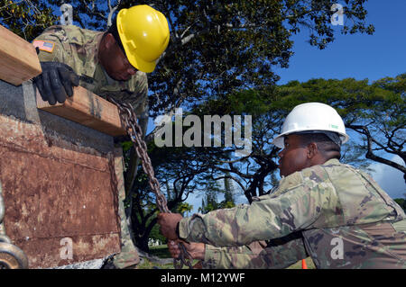 Bau Soldaten auf die 561St Ingenieur Gesellschaft zugeordnet, 84th Engineer Battalion, 130 Engineer Brigade, 8 Theater Sustainment Command, ein Denkmal sicher ist sicher bei Schofield Kasernen, Hawaii, Jan. 24, 2018 festgeschnallt. Die Techniker arbeiteten mit Marines Techniker Dienstleistungen Unternehmen, Bekämpfung Logistik Bataillon 3, Bekämpfung der Logistik Regiment 3, 3 Marine Logistik Gruppe, auf die Hilfe des 25 Infanterie Division 3. Brigade Combat Team Bronco Memorial bewegen. (U.S. Armee Stockfoto