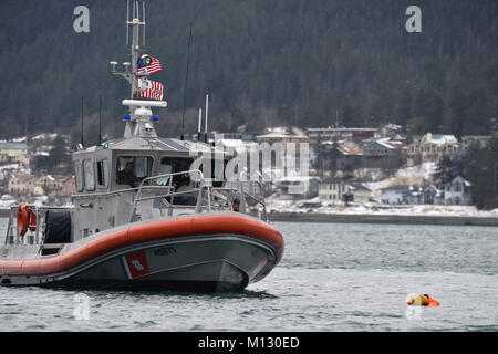 Mitglieder der Coast Guard Station Juneau an Bord eines 45-Fuß-antwort Boot - Medium, den Weg hin zu einem Dummy schwimmend im Wasser beim Leiten der Mann über Bord Ausbildung in Juneau, Alaska, Jan. 24, 2018. Station Juneau durchgeführt, um die Mann-über-Bord-Position Bohrer bei Frost zu erhalten neue Mitglieder boatcrew qualifiziert. Us-Küstenwache Stockfoto