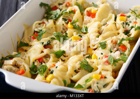 Gebackene Muscheln conchiglioni Nudeln mit Huhn, Pilzen und Gemüse gefüllte Makro in einer Auflaufform auf einem Tisch. Horizontale Stockfoto