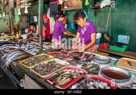 Barretto, Luzon, Philippinen - 12/22/2011: Ein älterer Filipina Frau splits Bangus Fisch an Fisch Ihrer Familie auf dem Markt von Barretto, Luzon, Phi Abschaltdruck Stockfoto