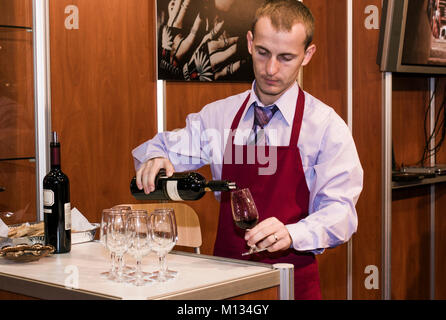 Sommelier Mann gießt Rotwein in ein Glas Stockfoto