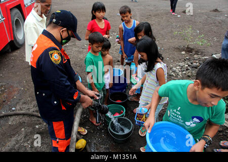 Junge Umsiedler Warteschlange ein sauberes Wasser während der Auslieferung vom Büro für Brandschutz im Inneren Ligao City National technische Berufsbildung High School Ligao Stadt, Albay, Bicol am 26. Januar 2018 erhalten. Das philippinische Institut für Vulkanologie und Seismologie (PHILVOLCS) erklärt alert Nummer 8 und breiter der Gefahrenzone 8 Kilometer Fläche nach Explosionen die weiterhin aktiv Aktivitäten des Vulkans der vergangenen Tage. Den Berichten zufolge ist es insgesamt 74.000 Personen sind betroffen und 100 Millionen von Schäden in der landwirtschaftlichen Flächen nach Abteilung für Landwirtschaft (DAR). (Phot Stockfoto