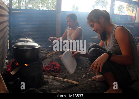 Rea Mae Madrona, 13 Jahre alt, beim Kochen Lebensmittel mit Holz von Brgy. Baligong innen Ligao City National technische Berufsbildung High School LigaoCity, Albay, Bicol am 26. Januar 2018. Das philippinische Institut für Vulkanologie und Seismologie (PHILVOLCS) erklärt alert Nummer 8 und breiter der Gefahrenzone 8 Kilometer Fläche nach Explosionen die weiterhin aktiv Aktivitäten des Vulkans der vergangenen Tage. Den Berichten zufolge ist es insgesamt 74.000 Personen sind betroffen und 100 Millionen von Schäden in der landwirtschaftlichen Flächen nach Abteilung für Landwirtschaft (DAR). (Foto von Gregor Stockfoto