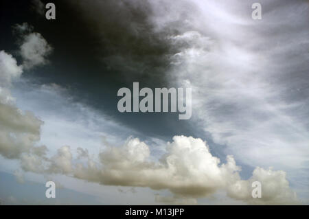 Schwere weiße Wolkenschichten in einem grauen Himmel mit weißen Streifen, Engelsflügel, Drachen, Seepferd oder Geistererscheinungen. Stockfoto