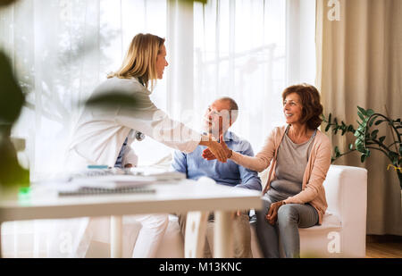 Ärztin im Gespräch mit einem älteren Ehepaar. Stockfoto