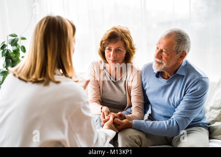 Ärztin im Gespräch mit einem älteren Ehepaar. Stockfoto