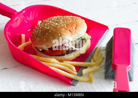 Fegen Junk Food Burger mit Pommes und Kehrblech Konzept der Gesundheit detox Diät Stockfoto