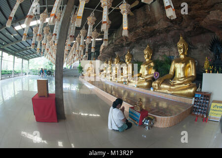 Reihe der goldene Buddha in der Höhle von Wat Tham Khuha Sawan Tempel ist auf einem hohen Felsen über dem Fluss Mekong. Khong Chiam, Ubon Ratchathani, Tha entfernt Stockfoto