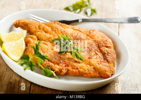 Panierte gebratene Fleisch mit einer frischen Zitrone Keil Stockfoto