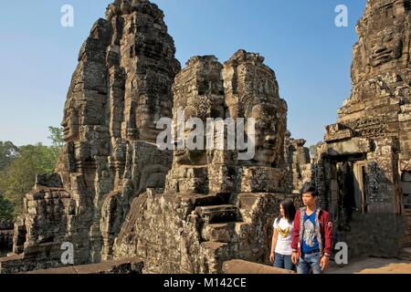 Kambodscha, Angkor, als Weltkulturerbe von der UNESCO, junge kambodschanische Paar in der Mitte des geschnitzten Köpfen der Bodhisattva die Komposition der Bayon, die wichtigsten Tempel der alten Khmer Stadt Angkor Thom Stockfoto