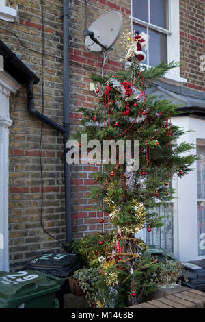 Ein Baum mit Weihnachtsschmuck gekleidet sitzt außerhalb eines viktorianischen Reihenhaus in Herne Hill, SE24, am 18. Dezember 2017 in London, England. Stockfoto