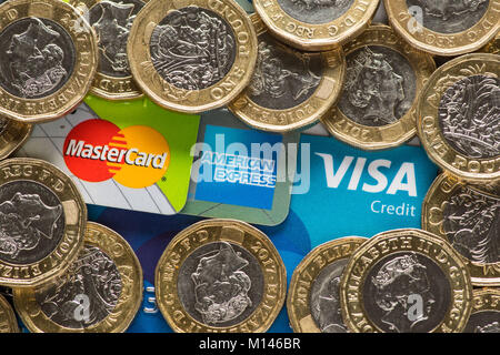 Mastercard, American Express und Visa Kreditkarten mit Großbritannien ein Pfund Münzen. Stockfoto