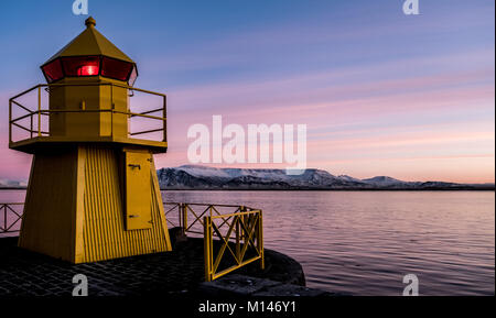 Ein Leuchtturm in Reykjavik alte Hafen mit Esja im Hintergrund. Bei Sonnenaufgang. Stockfoto