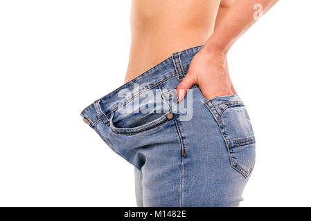 Frau zeigt, dass Sie Gewicht verloren hat. Big Jeans. Stockfoto