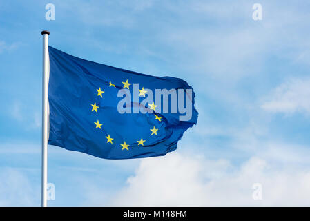 Nahaufnahme des einheitlichen europäischen Flagge mit zwölf gelben Sternen winken im Wind vor blauem Himmel Stockfoto