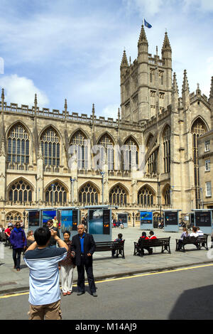 Bath, Großbritannien - 19.. Juni 2011: Besucher, die bei der Sommersonne in der Stadt Bath, Somerset, Großbritannien, für einen Schnappschuss von Bath Abbey posieren. Bath ist ein UNESCO-Weltkulturerbe und berühmt für seine Architektur, die das ganze Jahr über Besucher anzieht. Stockfoto