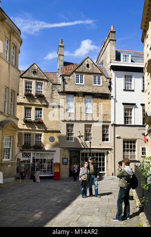 Bath, Großbritannien - 19.. Juni 2011: Besucher posieren für ein Foto in der Nähe des Teeladens Sally Lunns bei der Sommersonne in der Stadt Bath, Somerset, Großbritannien. Sally Lunns ist eines der ältesten Häuser in Bath und beherbergt das ursprüngliche Bath Bun. Bath ist ein UNESCO-Weltkulturerbe und berühmt für seine Architektur, die das ganze Jahr über Besucher anzieht. Stockfoto