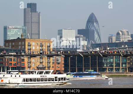 London, Großbritannien - 23.. März 2012: Die Frühlingssonne ermutigt Besucher und Londoner gleichermaßen, die Themse zu Fuß über die Millenium Bridge zu überqueren. Die Millennium Bridge ist eine Hängebrücke, die die Themse in London überquert und Bankside mit der Stadt verbindet. Stockfoto