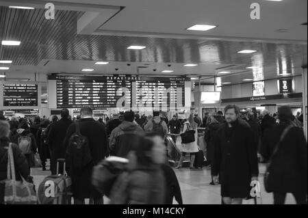 Ein müdes Publikum ist Warten vor der Abreise in New York Penn Station für Bahn home Stockfoto