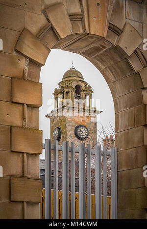 Ein Blick auf die Stadt Hall Clock Tower in Clydebank durch einen nahe gelegenen Torbogen. Stockfoto