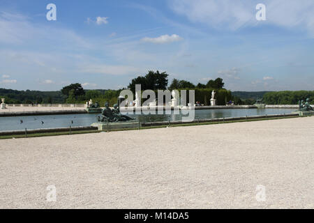 Blick auf Pool mit den umliegenden Statuen in Versailles Palace Gardens, Ile de France, Frankreich. Stockfoto