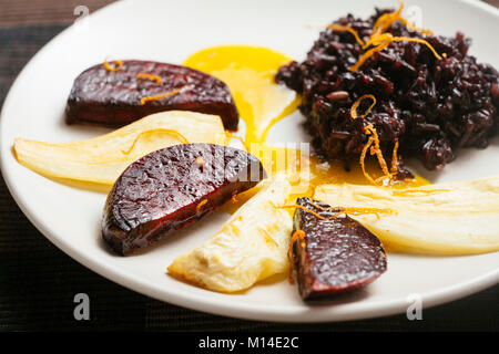 Lila verboten Reis mit gebratenen Pastinaken und Rote Rüben mit Orangensauce Stockfoto