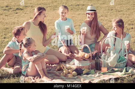 Portrait von erwachsenen Frauen mit glücklichen Kindern im Sommer Picknick im Park Stockfoto