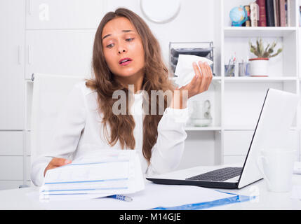 Deprimiert junge Frau mit Serviette, die Schwierigkeiten bei der Arbeit im Büro Stockfoto