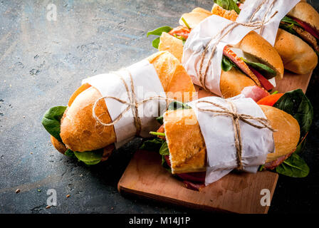 Frisches Baguette Sandwich mit Schinken, Käse, Tomaten und Spinat, dunkelblauen Hintergrund Kopie Raum Stockfoto