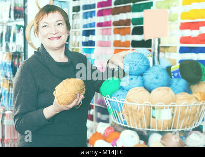 Reife Frau Auswahl Vielzahl Garn für Ihr Hobby in Handarbeit shop Stockfoto