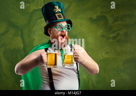 Ein dicker Mann mit Bart in St. Patrick's Anzug ist lächelnd mit einem m Stockfoto