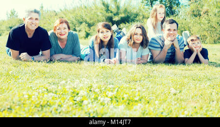 Positive Familie unterschiedlichen Alters die Bilder auf dem Rasen Stockfoto