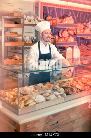 Nach Kerl ist mit frischen leckeren Croissants in der Bäckerei. Stockfoto