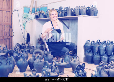 Portrait von weiblichen Handwerker mit Schwarz verglaste Keramik Vasen im Atelier Stockfoto