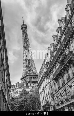 Blick von einer kleinen Straße der Altstadt in Paris, um den Eiffelturm in den Farben Schwarz und Weiß. Stockfoto