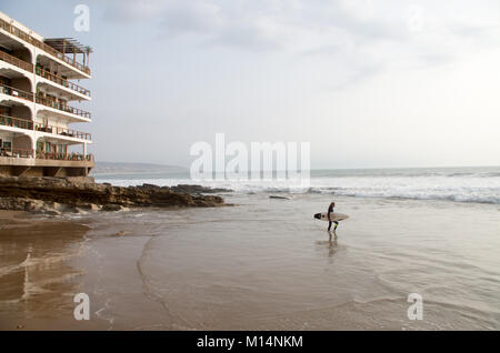 Surfer geht in das Wasser einige Wellen in Taghazout, Januar 2018 zu fangen Stockfoto