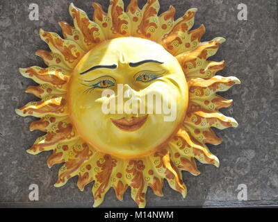 Handgefertigte Keramik gelb symbolische Sonne Siziliens an der Wand im Zentrum von Taormina mit Lächeln und Strahlen in 2016 warmen sonnigen Tag in Italien. Stockfoto