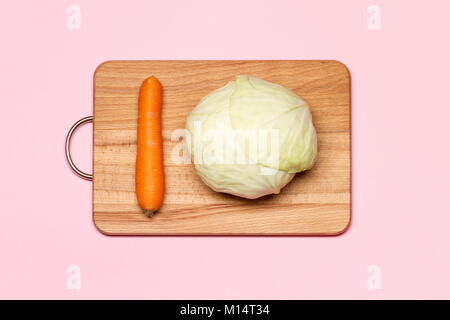 Das gesunde Essen. Ein frischer Weißkohl in der Nähe von Karotte auf einer hölzernen Schneidebrett Stockfoto