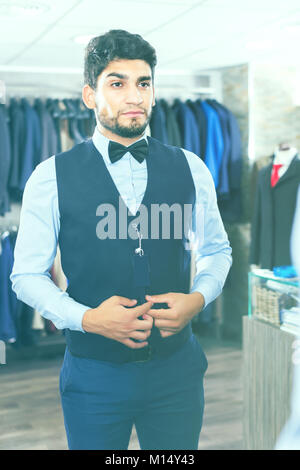 Shopper versucht, der auf ausgewählten Bild vor dem Spiegel in der Männer Shop. Stockfoto