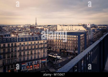 Dachterrasse mit Blick über Paris, Frankreich von einem Balkon über den historischen Wohnhäusern und Straßen zu einem weit entfernten Eiffelturm suchen am Horizont auf einem Glo Stockfoto