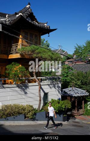 Südkorea, Seoul, Fabien Yoon, ein Star der koreanischen Medien, in eine steile Straße vor einem hölzernen traditionellen Haus Stockfoto