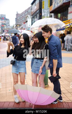 Südkorea, Seoul, Fabien Yoon, französischen Star der Koren medias in einem selfie mit Jungen groupies Mädchen im Bezirk von Hongdae Stockfoto