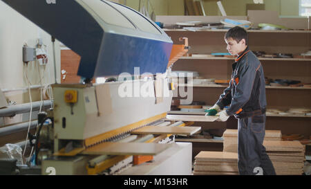 Arbeitnehmer Tischler griffe Holzmöbeln Teilen in der Maschine auf die Werkseinstellungen Stockfoto